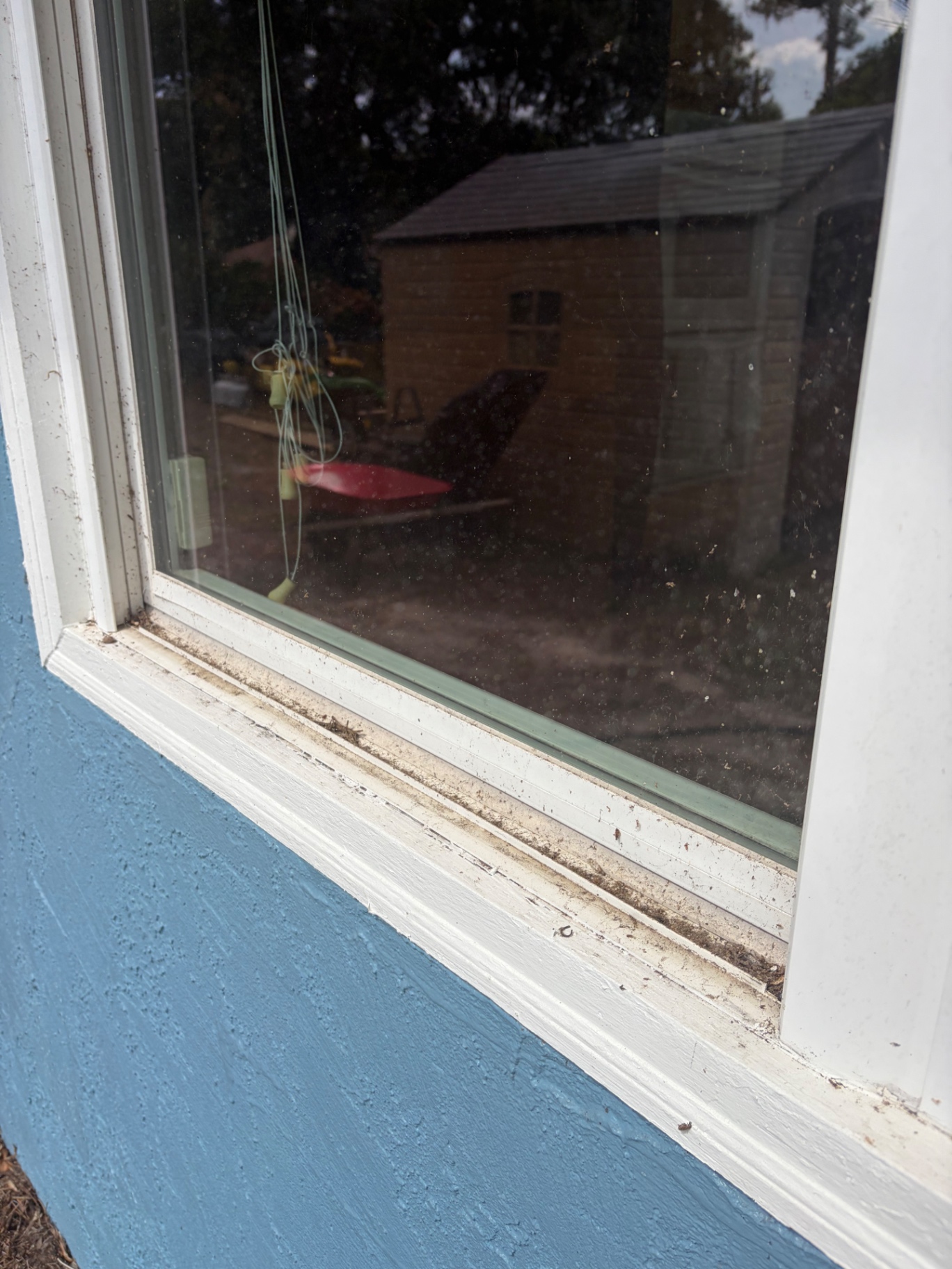 Before: dirty exterior sill and hazy glass on a Navarre home